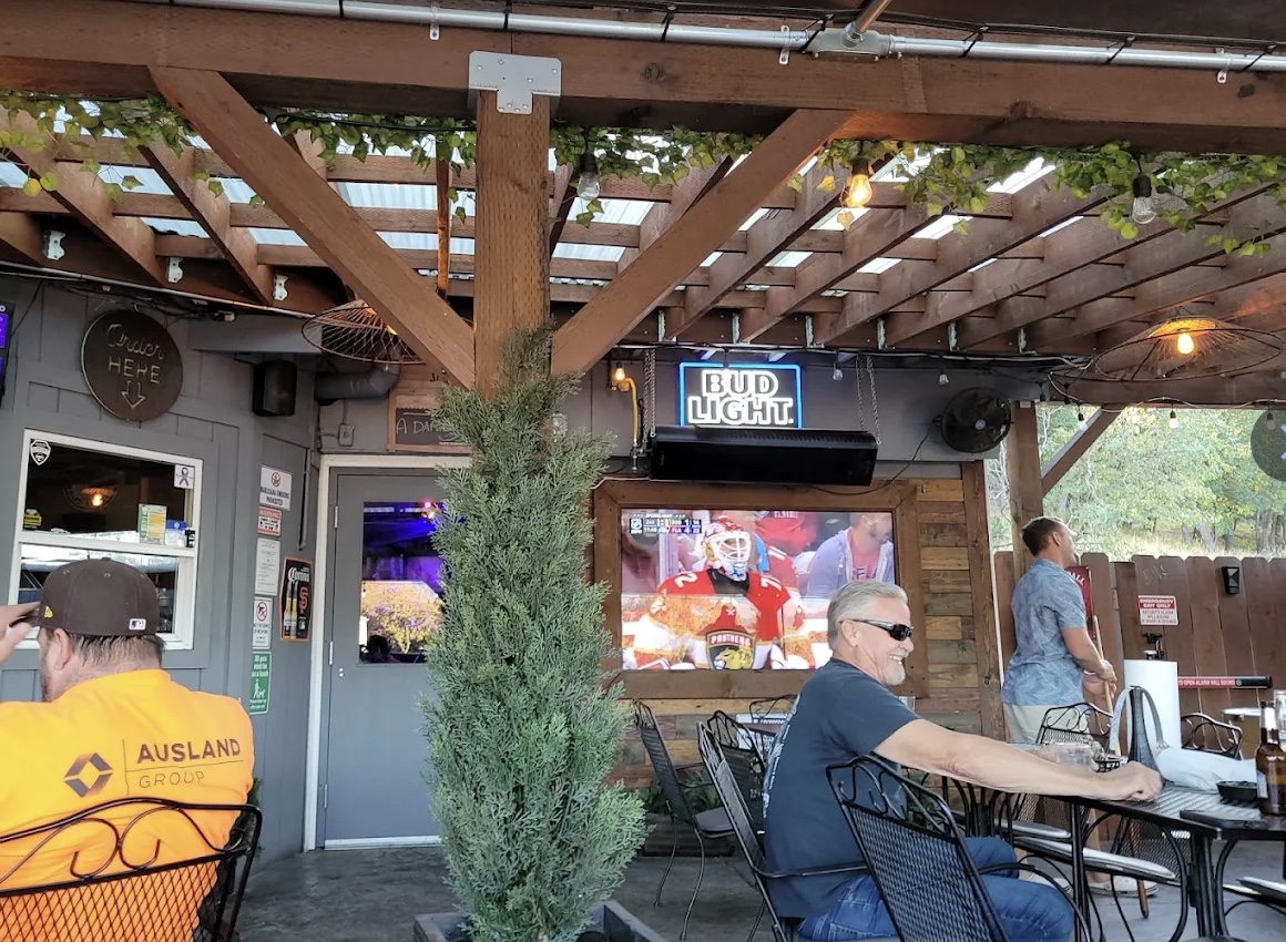 Friends relaxing beneath the covered patio at Flespy’s