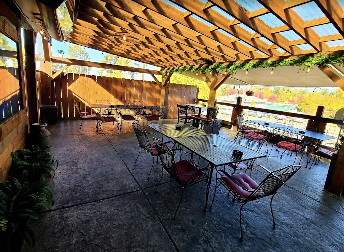 Flespy’s covered wood patio with string lights and red chairs