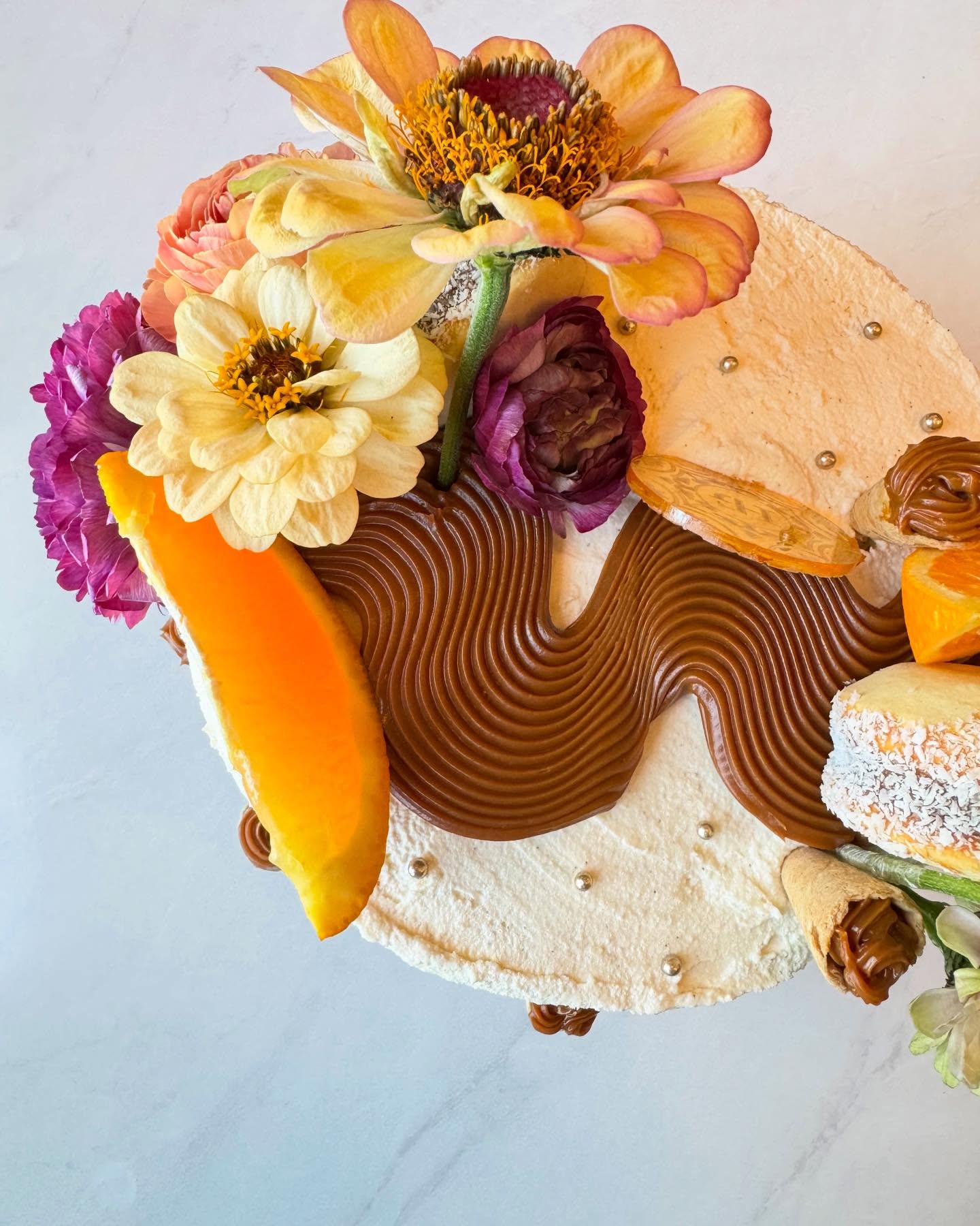 An elaborate House of Glory dessert decorated with fresh flowers