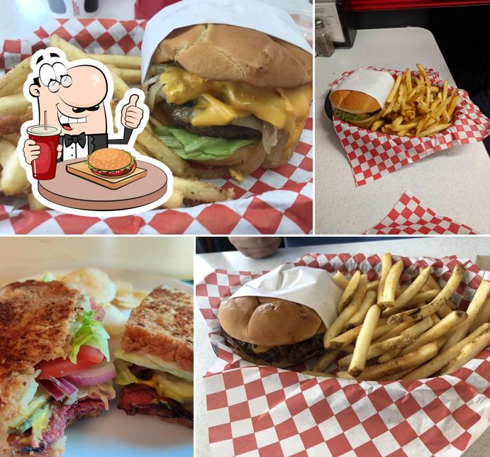 Several Jimmy's cheeseburgers with lettuce and melted cheese alongside baskets of seasoned fries