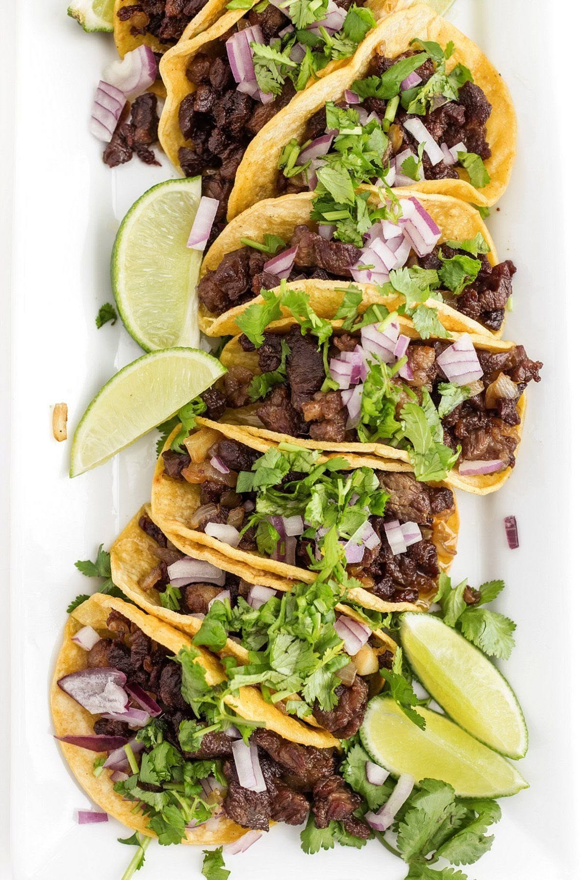 Carne asada tacos with cilantro, red onion, and lime