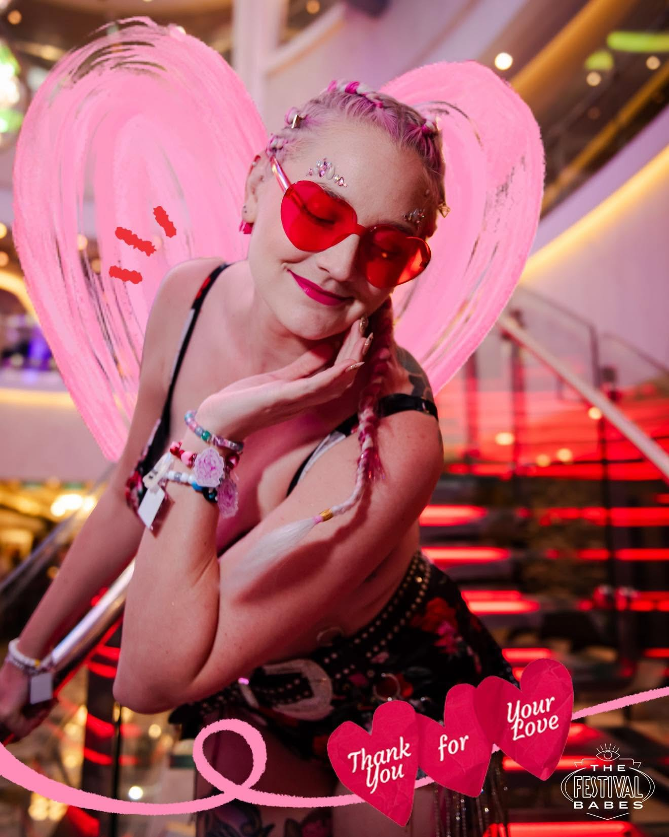 Brittany wearing pink heart-shaped glasses with pink angel wings behind her