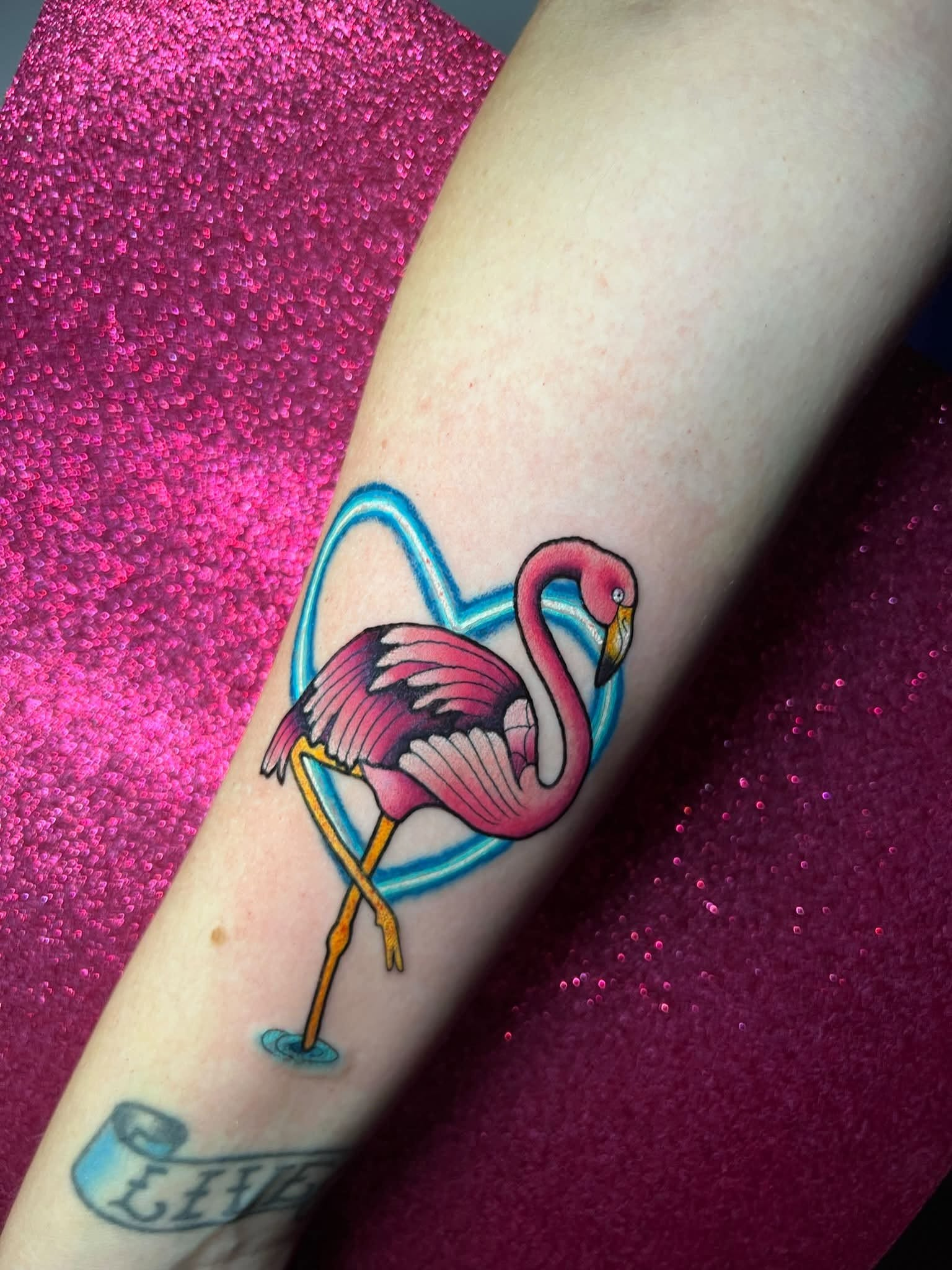 Pink flamingo inside a blue heart tattoo